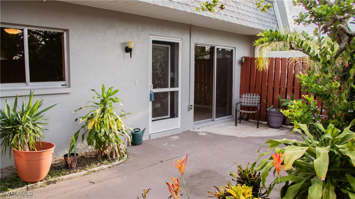 a potted plant sitting in front of a house with potted plants