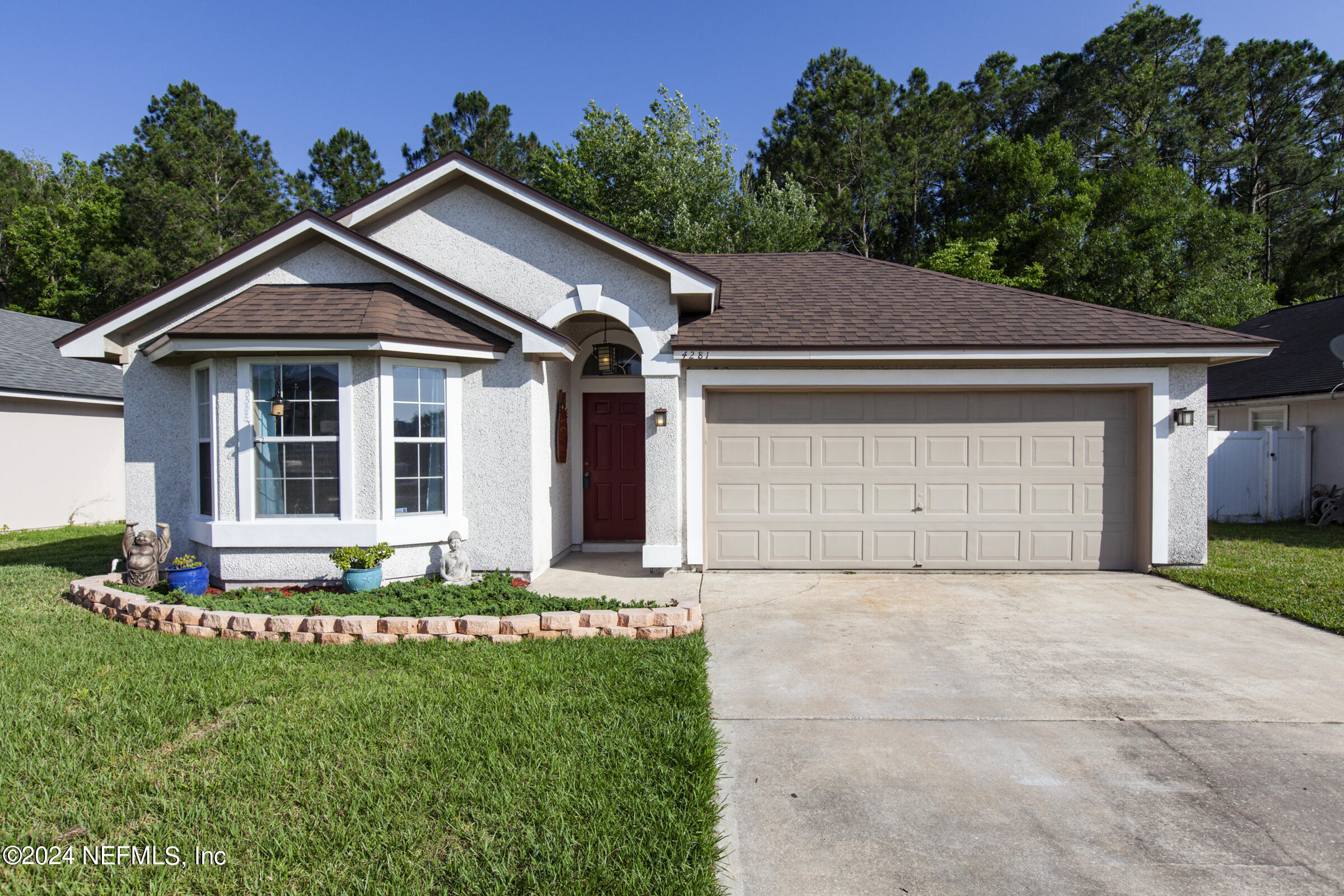 a front view of a house with a garden and plants