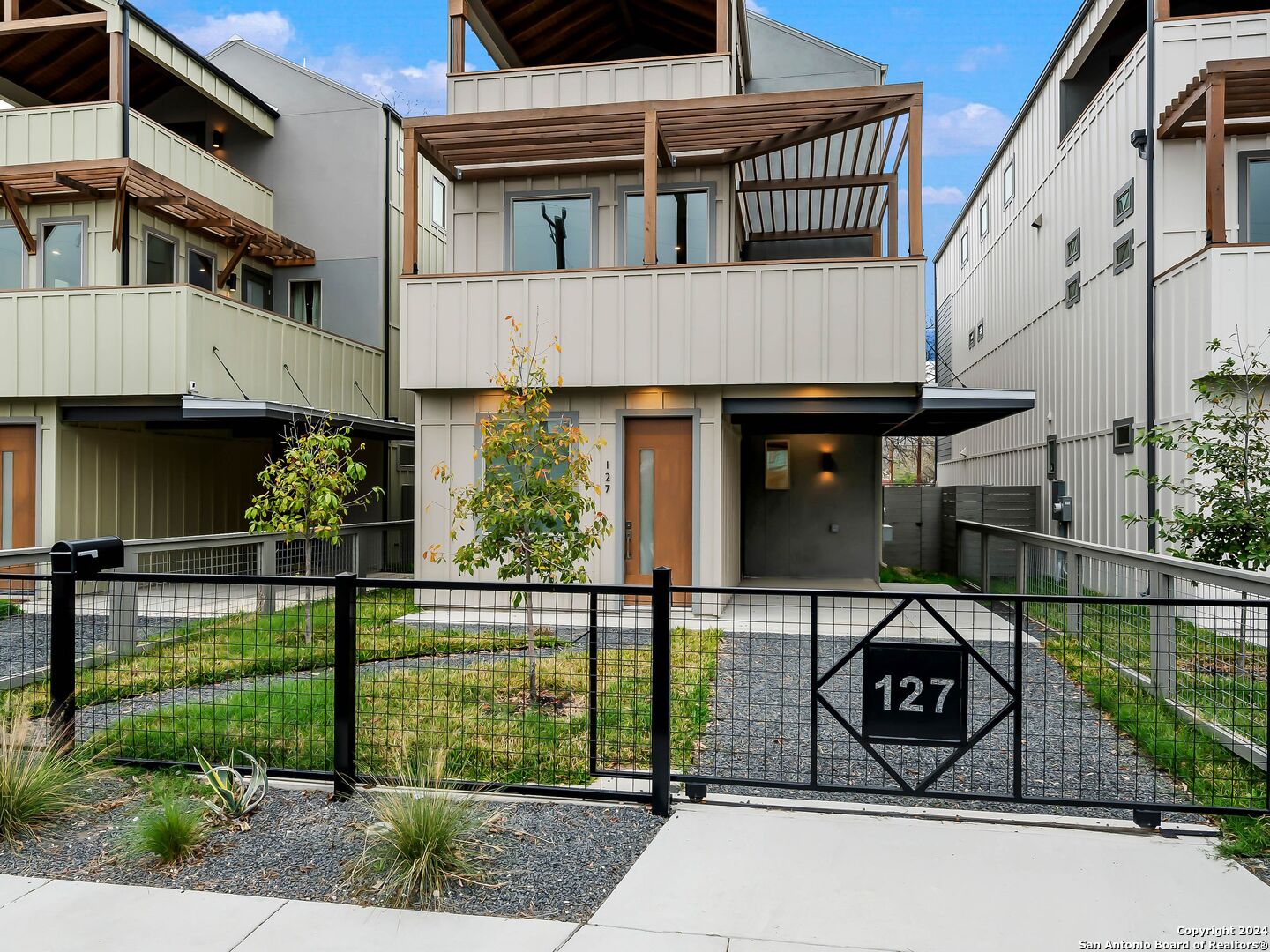 a view of a house with a small yard and potted plants