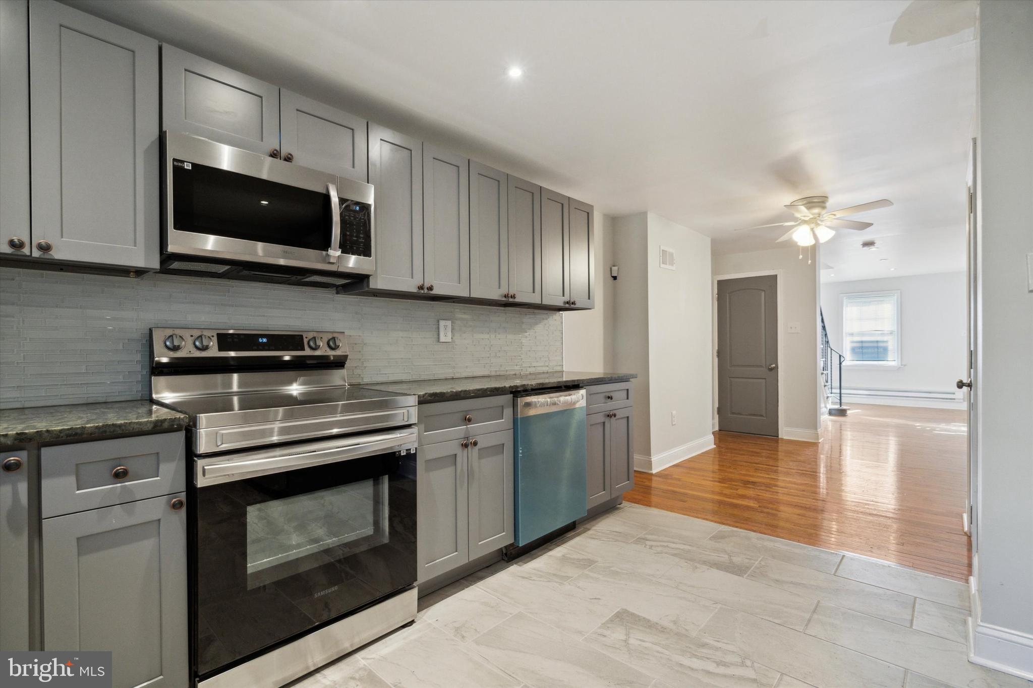 a kitchen with stainless steel appliances granite countertop a stove and a microwave