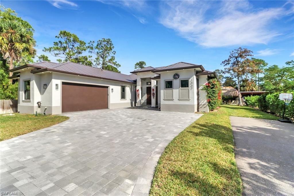 View of front of property featuring a garage and a front lawn