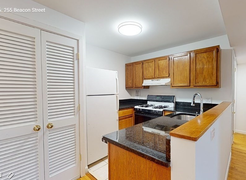 a kitchen with stainless steel appliances granite countertop sink stove top oven and cabinets