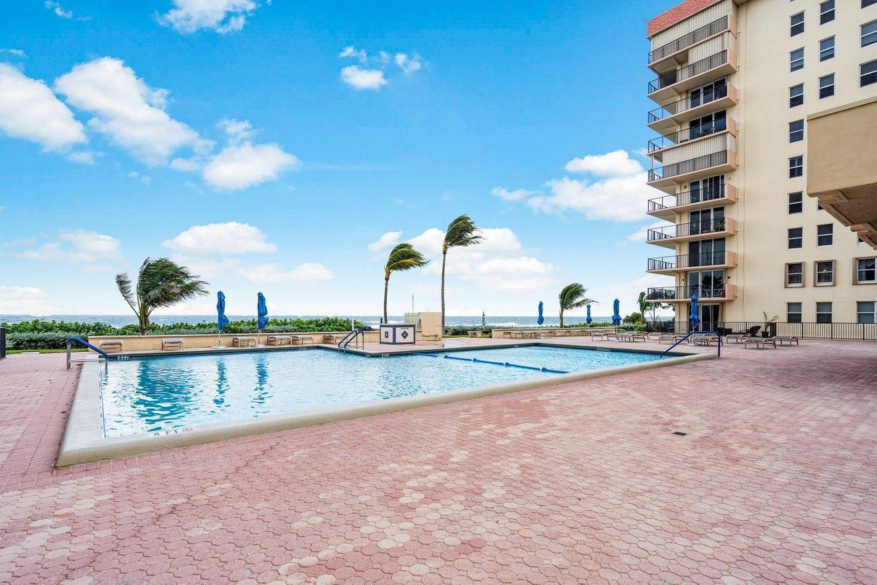 a view of swimming pool with outdoor seating and a lake view