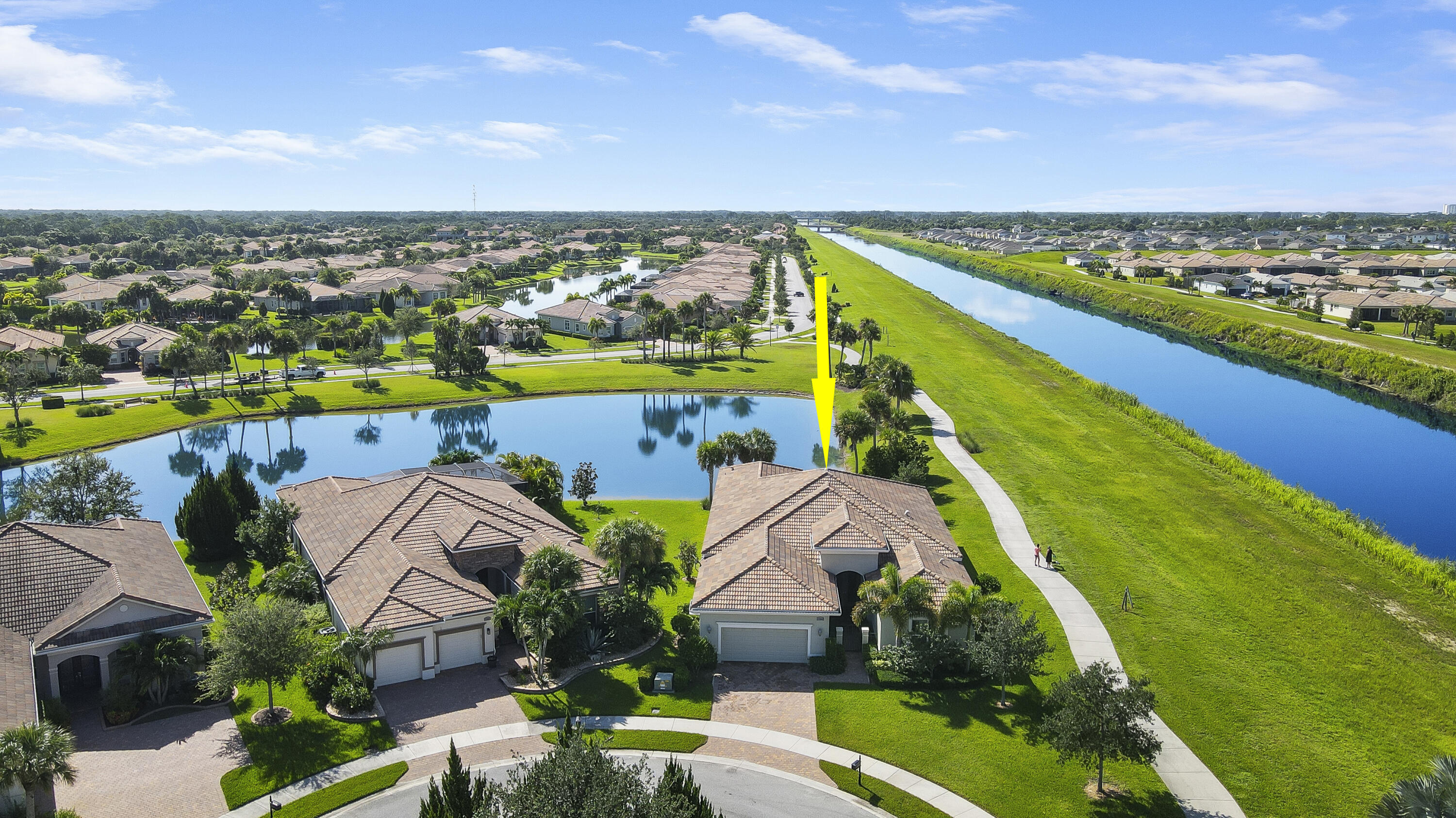 an aerial view of a house with a swimming pool yard and lake view in back