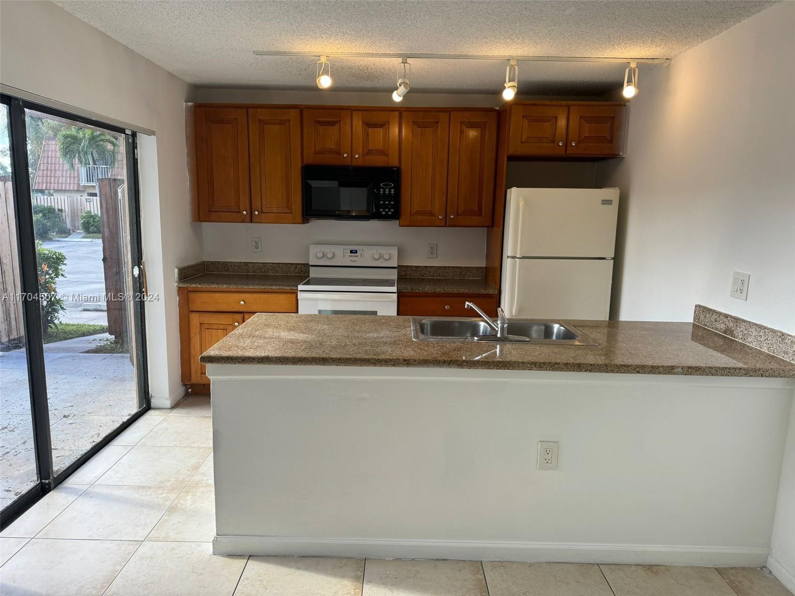 a kitchen with stainless steel appliances granite countertop a sink a stove and a refrigerator