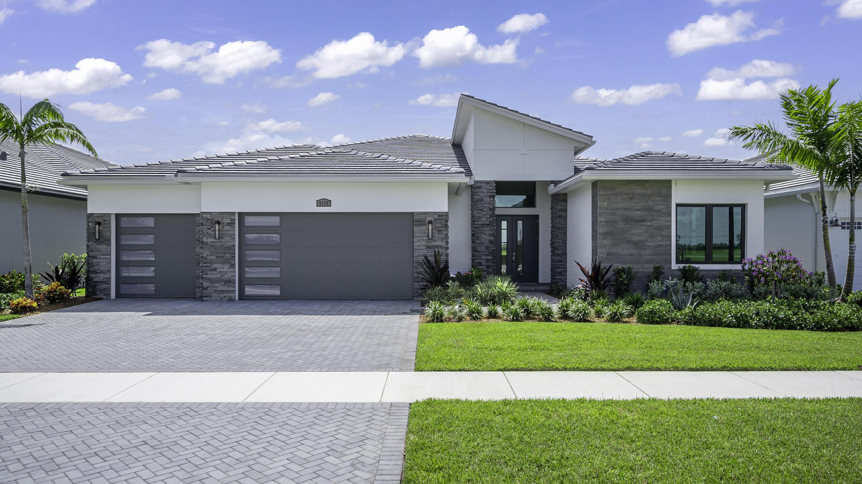 a front view of a house with a yard and garage