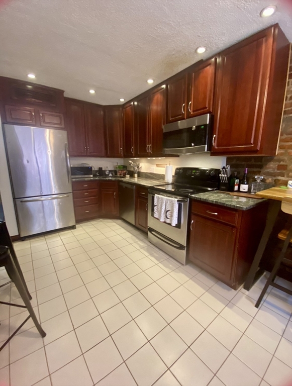 a kitchen with stainless steel appliances granite countertop a stove a sink dishwasher and a refrigerator