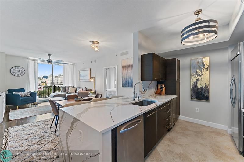 a kitchen with a stove a kitchen island a sink and a refrigerator