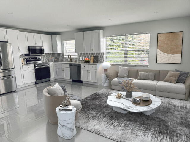 a living room with furniture and kitchen view