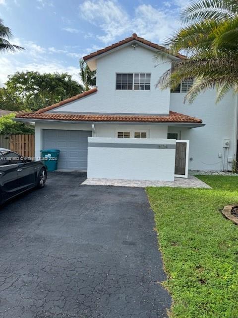 a view of a house with a yard and a garage