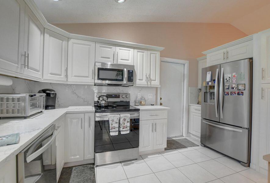 a kitchen with stainless steel appliances granite countertop a refrigerator stove a sink and a microwave