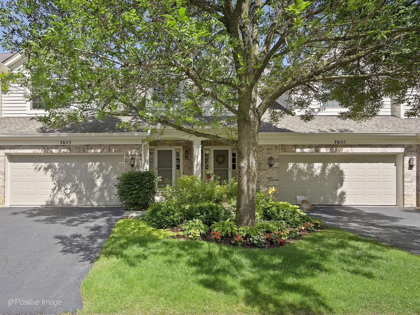 a front view of a house with a garden and yard