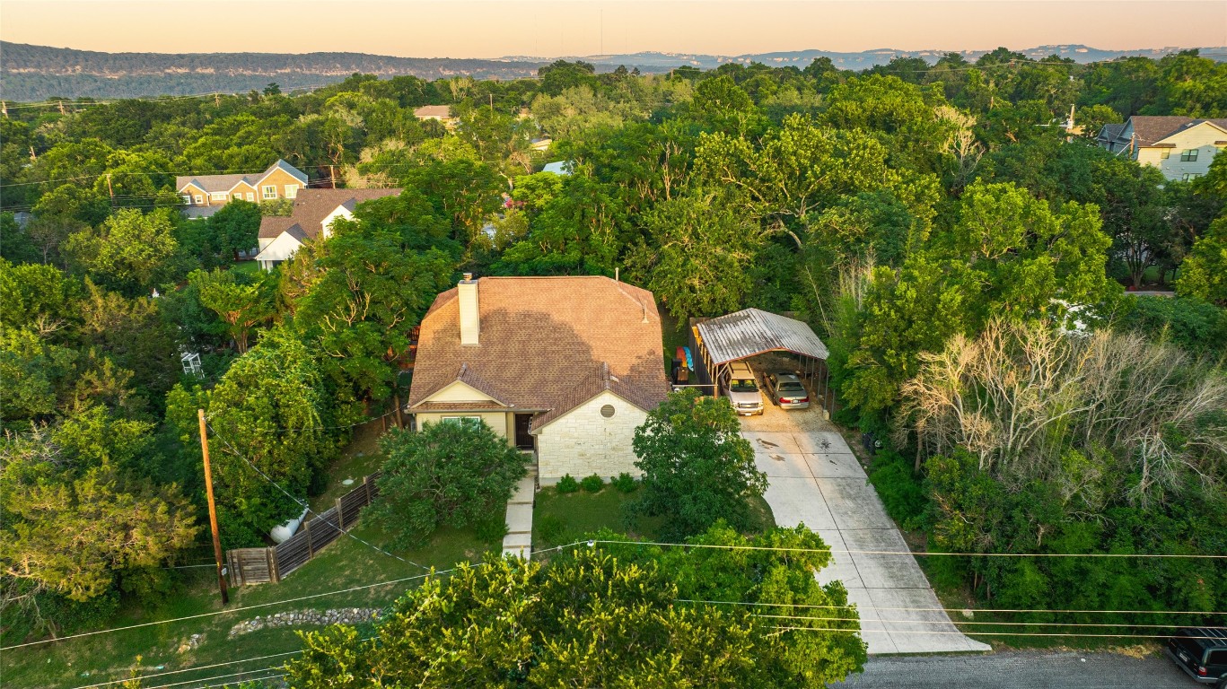 a aerial view of a house with a yard and trees