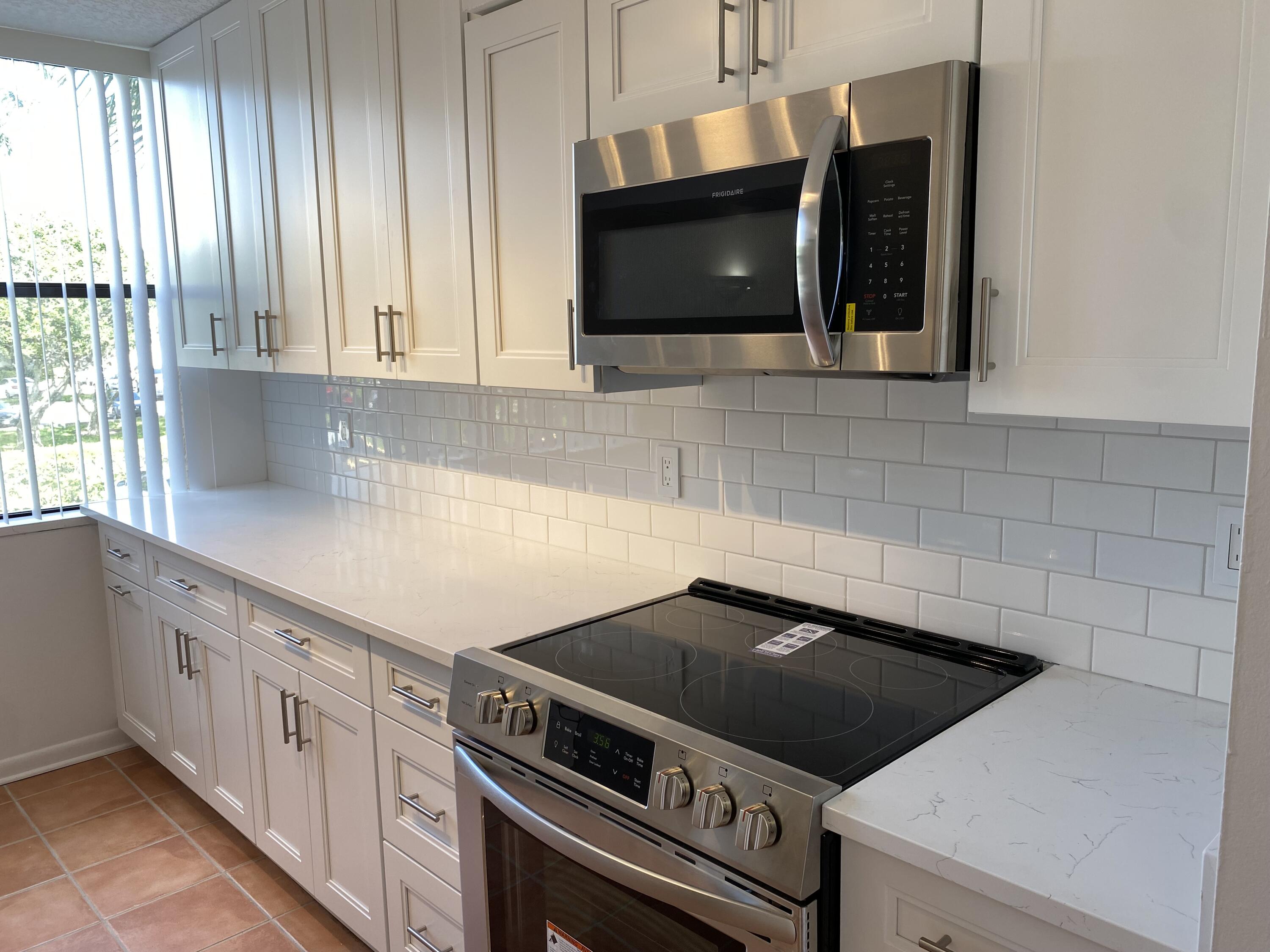 a kitchen with microwave cabinets and a stove top oven