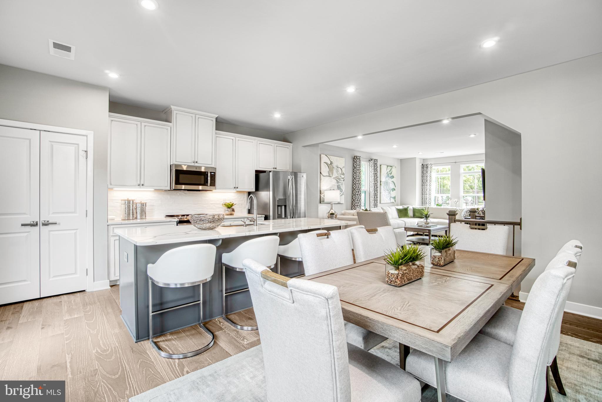 a kitchen with a dining table chairs and white cabinets