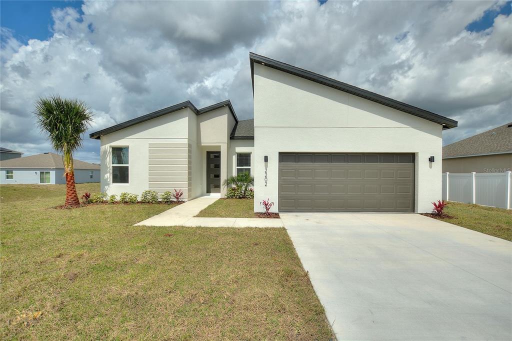 a front view of a house with yard and garage