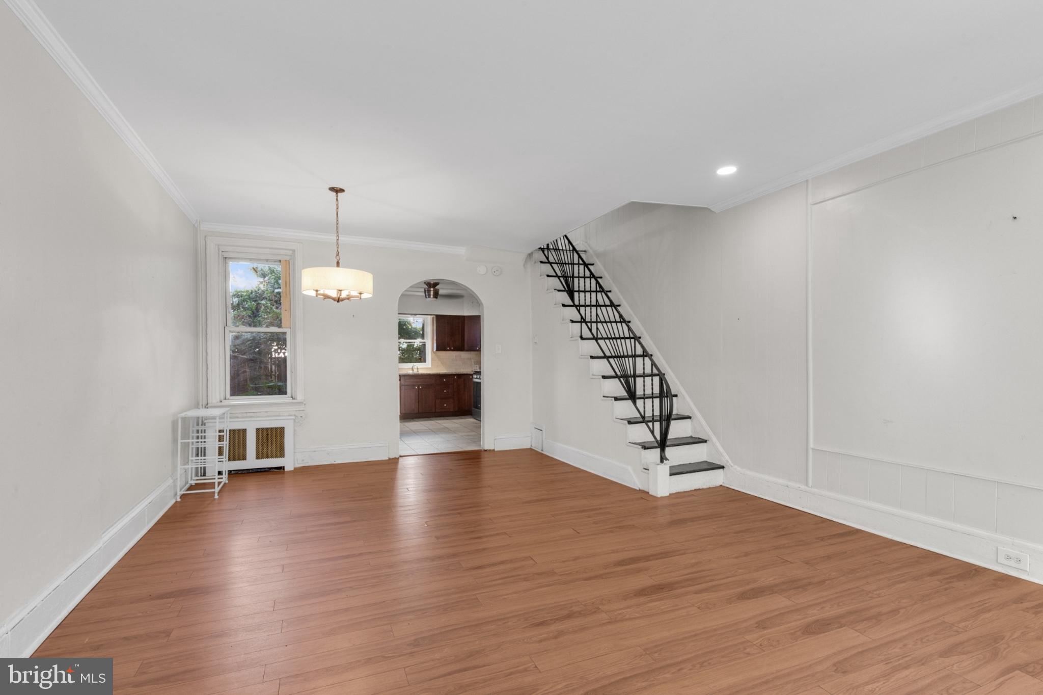 a view of a livingroom with wooden floor and staircase