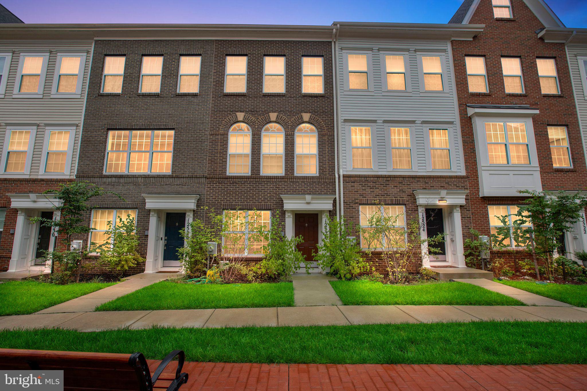 a front view of a brick house with a yard