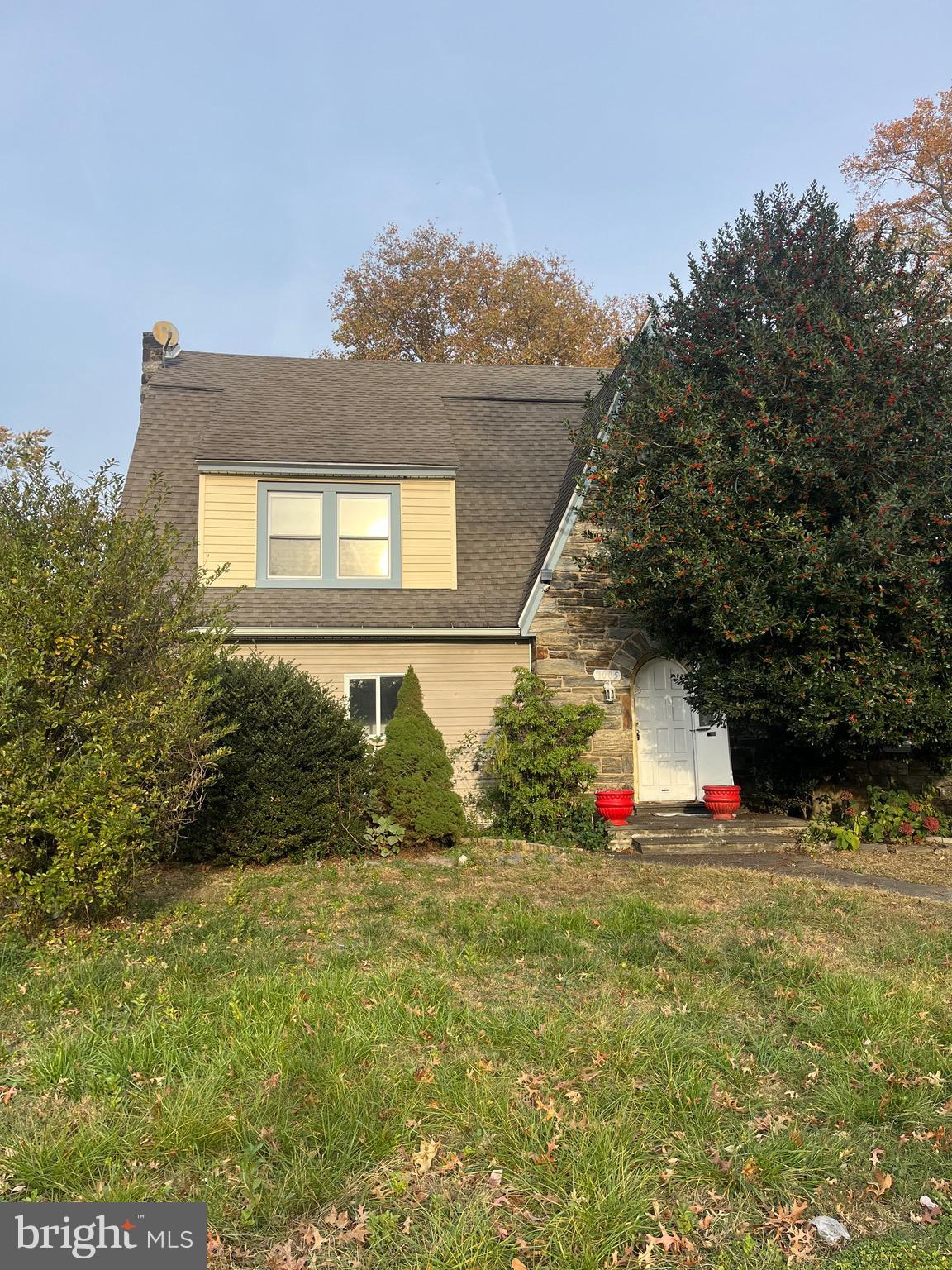 a view of yellow house with the yard and sitting space