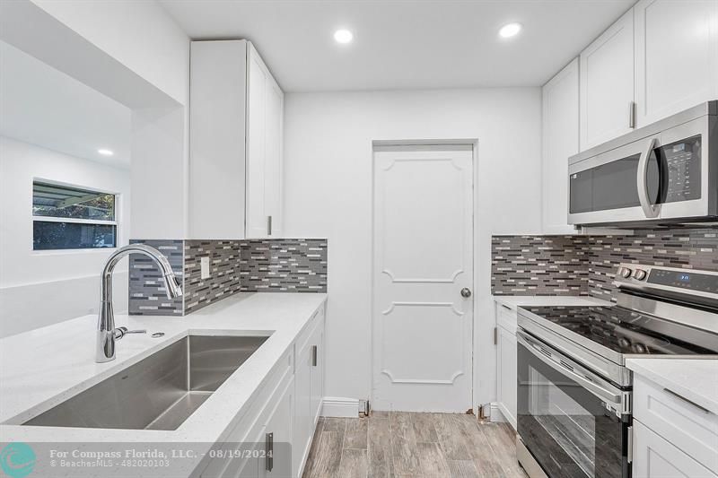 a kitchen with granite countertop a stove and a sink