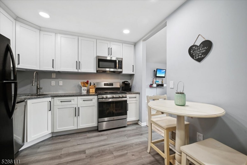 a kitchen with a sink cabinets and wooden floor