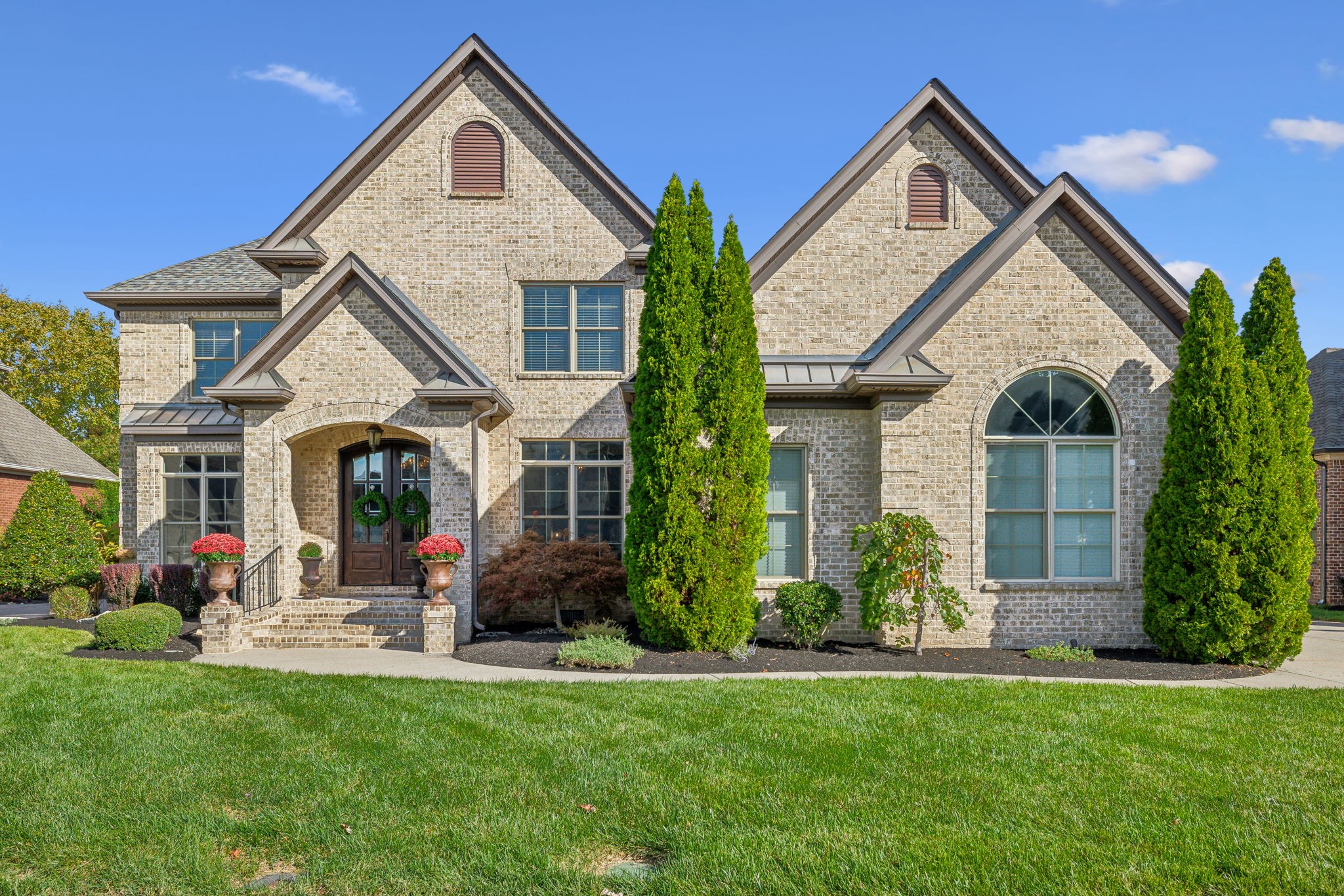 a front view of a house with a yard and plants