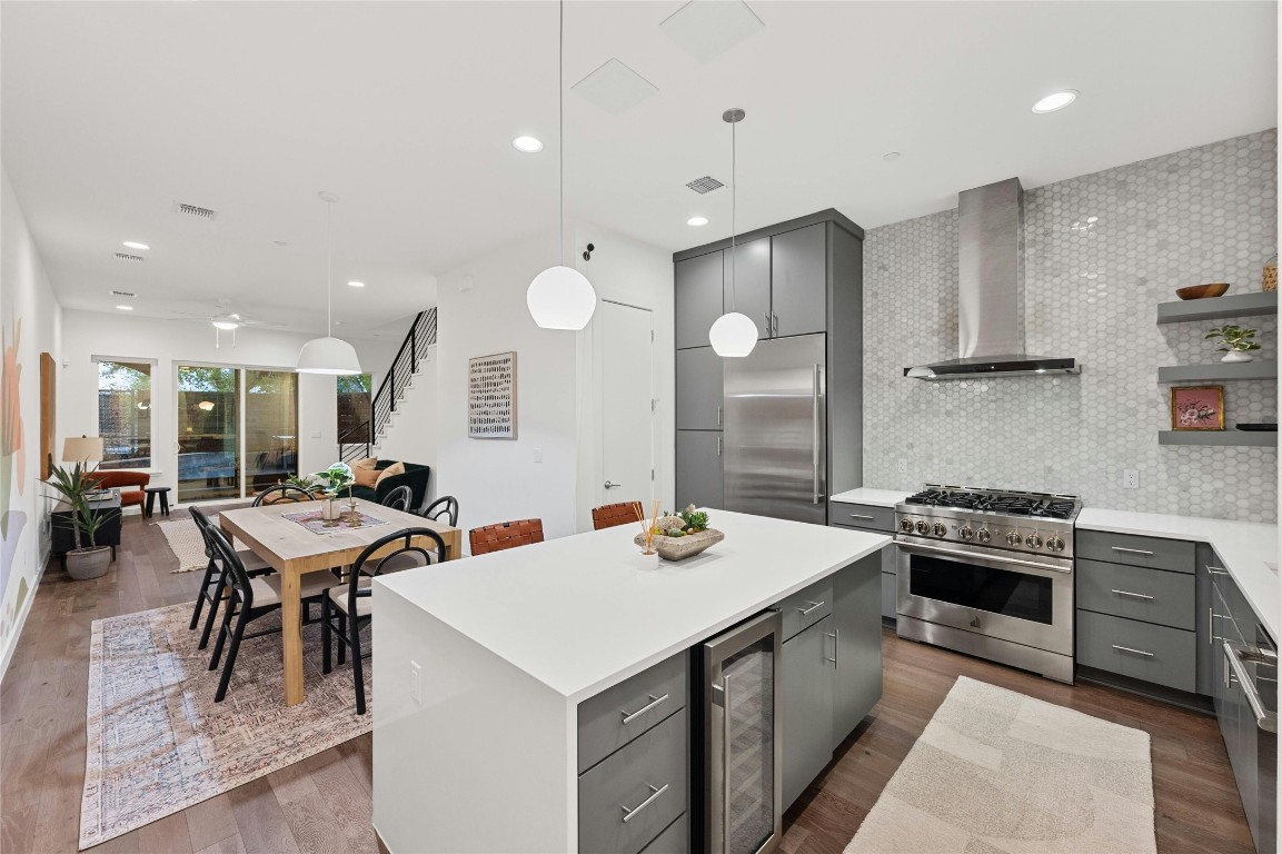 a kitchen with a stove a sink a kitchen island with chairs and wooden floor