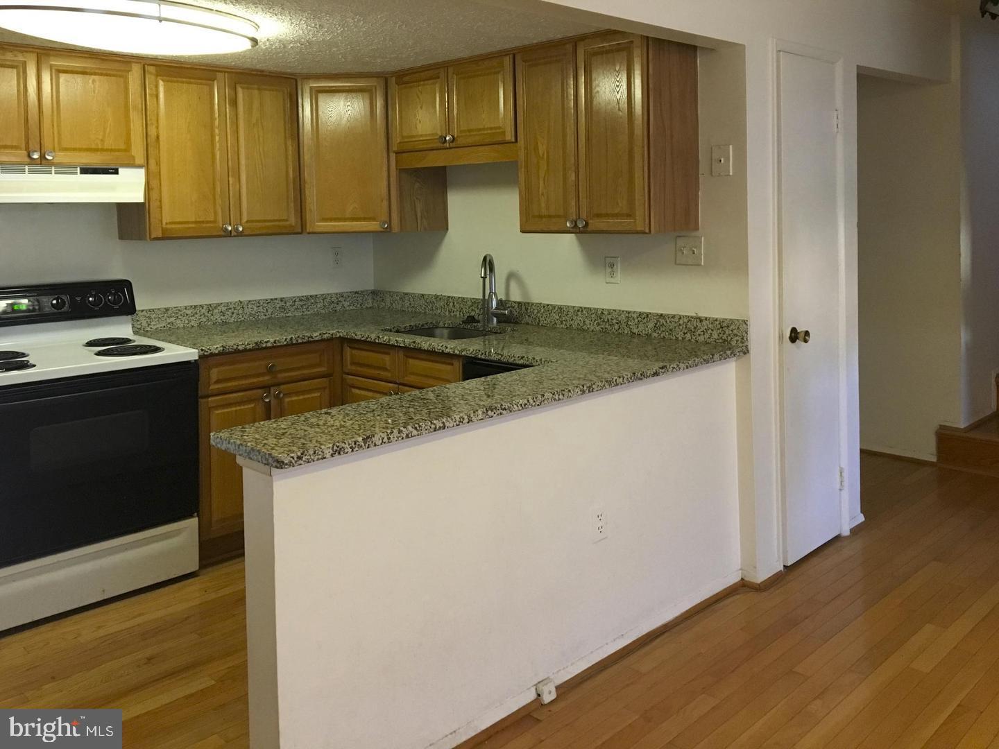 a kitchen with granite countertop a sink and a stove top oven