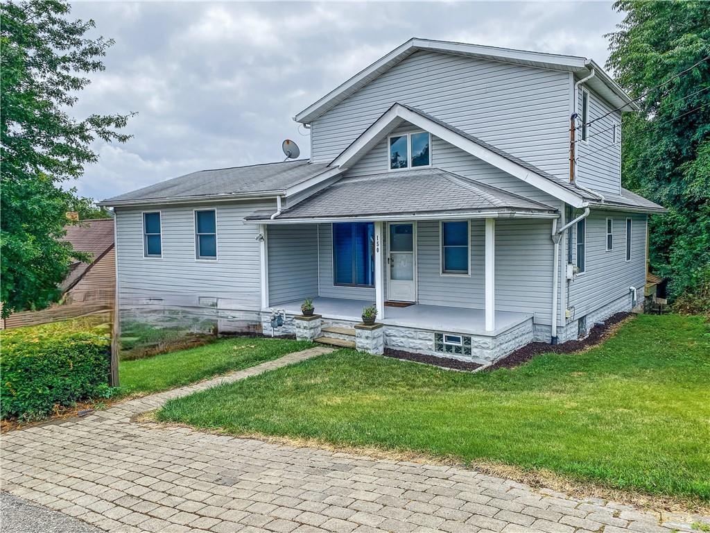 a front view of a house with a garden and yard