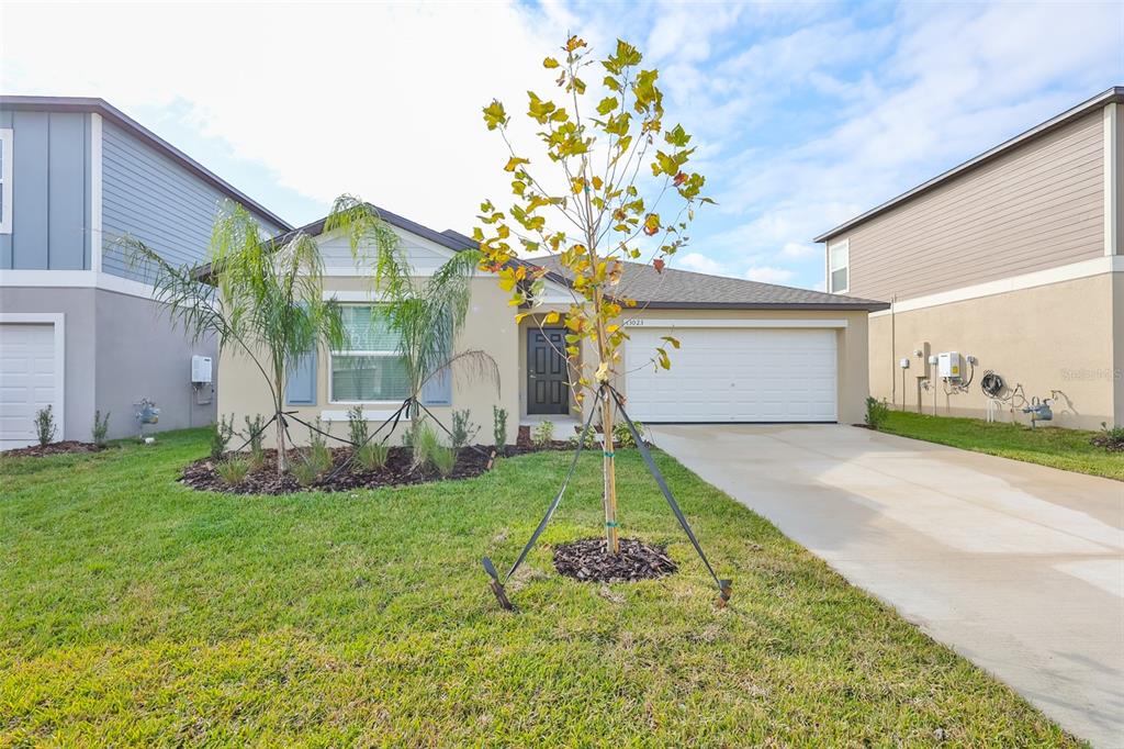 a front view of a house with a yard and garage