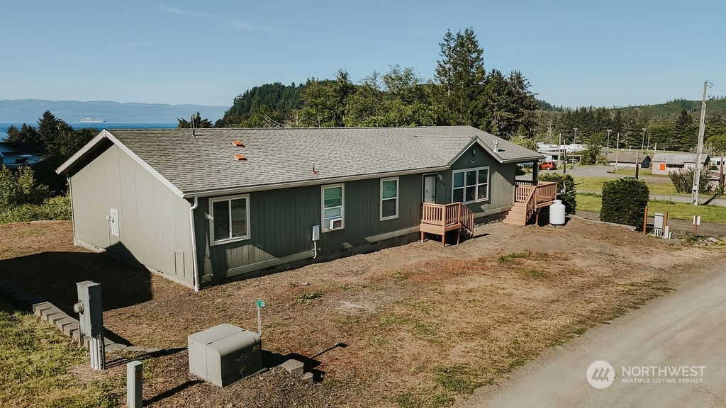 a view of a house with backyard and trees in the background