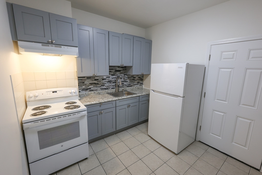 a kitchen with a stove top oven sink and refrigerator