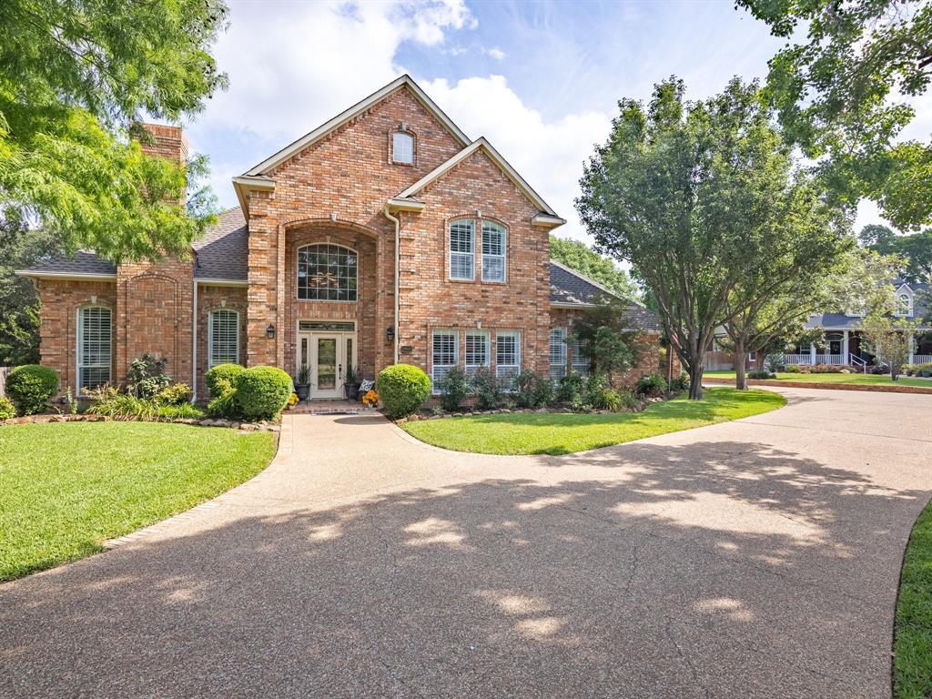 a view of a house with a big yard and large trees