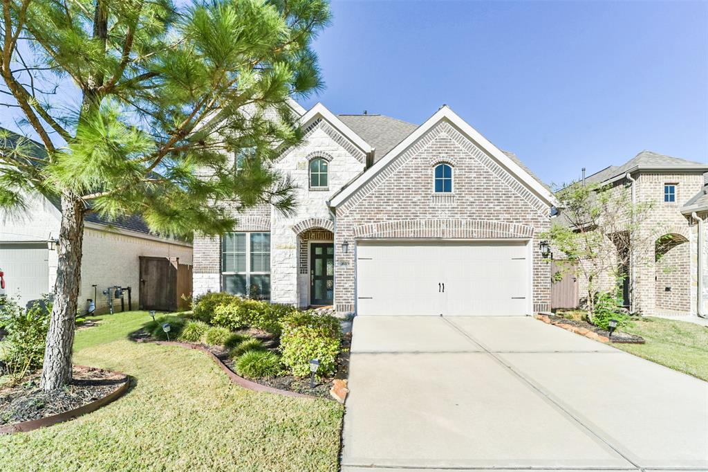 This is a two-story brick & stone home featuring a well-kept front lawn with landscaping, a two-car garage, and a welcoming entrance! Let's check it out!