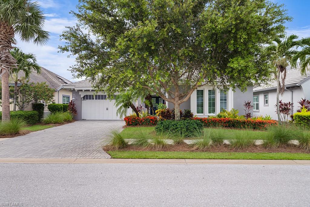 a front view of a house with a yard and shrubs