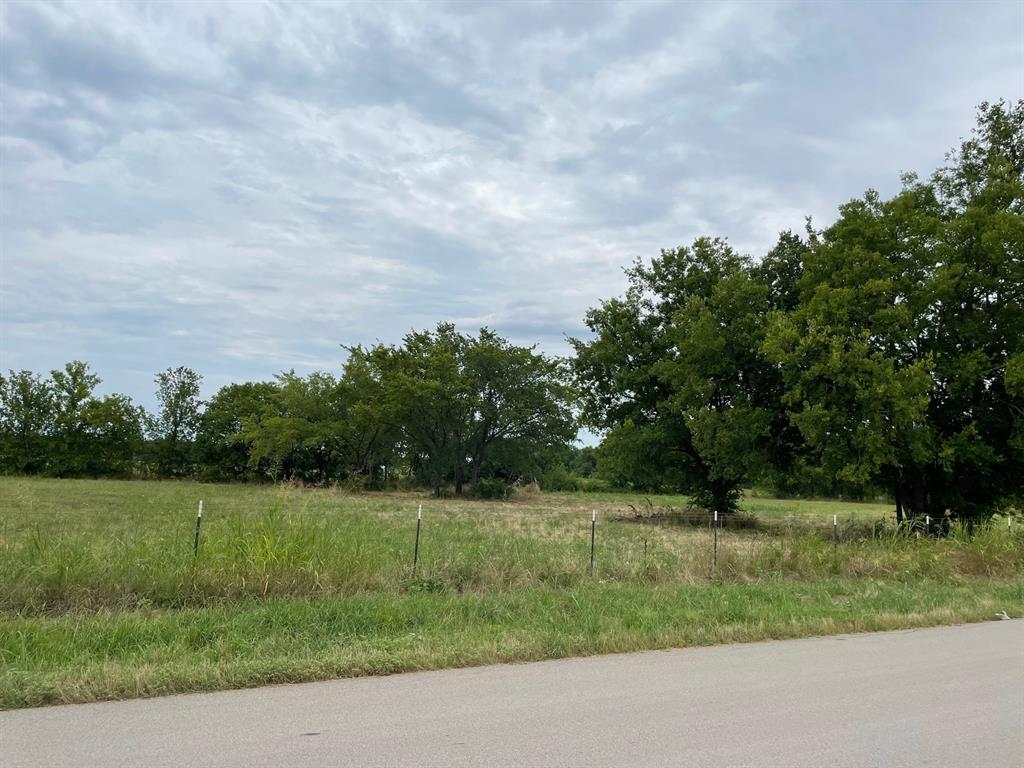 a view of a green field with wooden fence