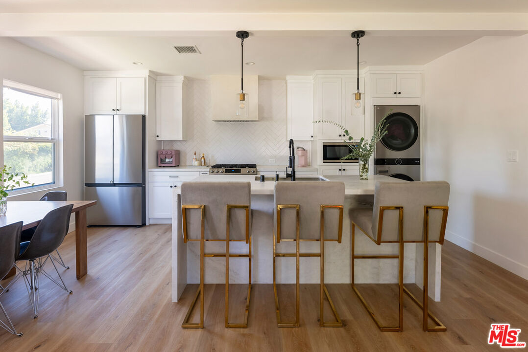 a view of kitchen with refrigerator and wooden floor