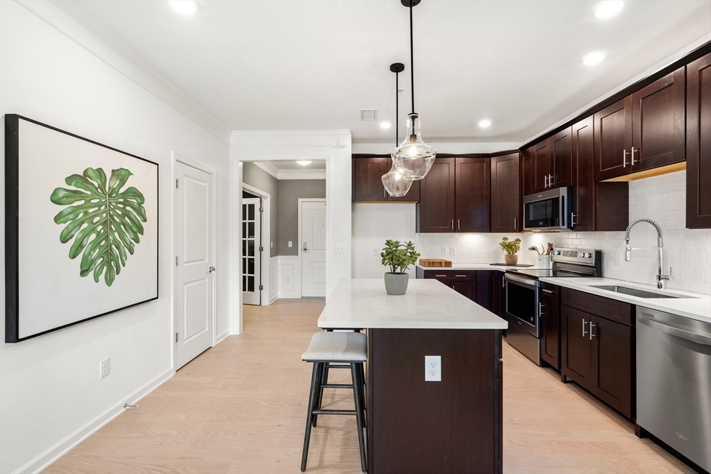 a kitchen with stainless steel appliances granite countertop a sink a stove and a wooden floors