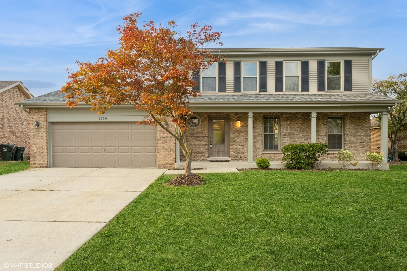 a front view of a house with a garden and yard