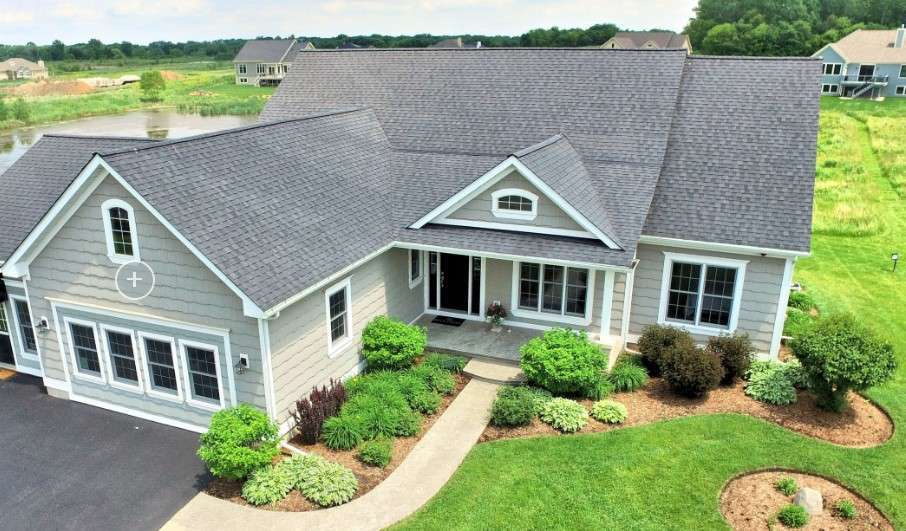 a aerial view of a house next to a yard with plants and trees