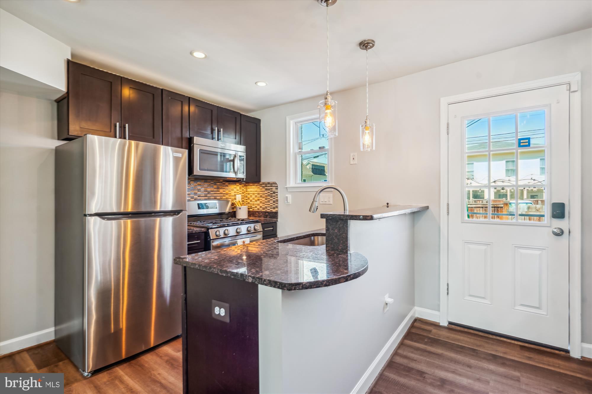 a kitchen with stainless steel appliances granite countertop a refrigerator and a sink