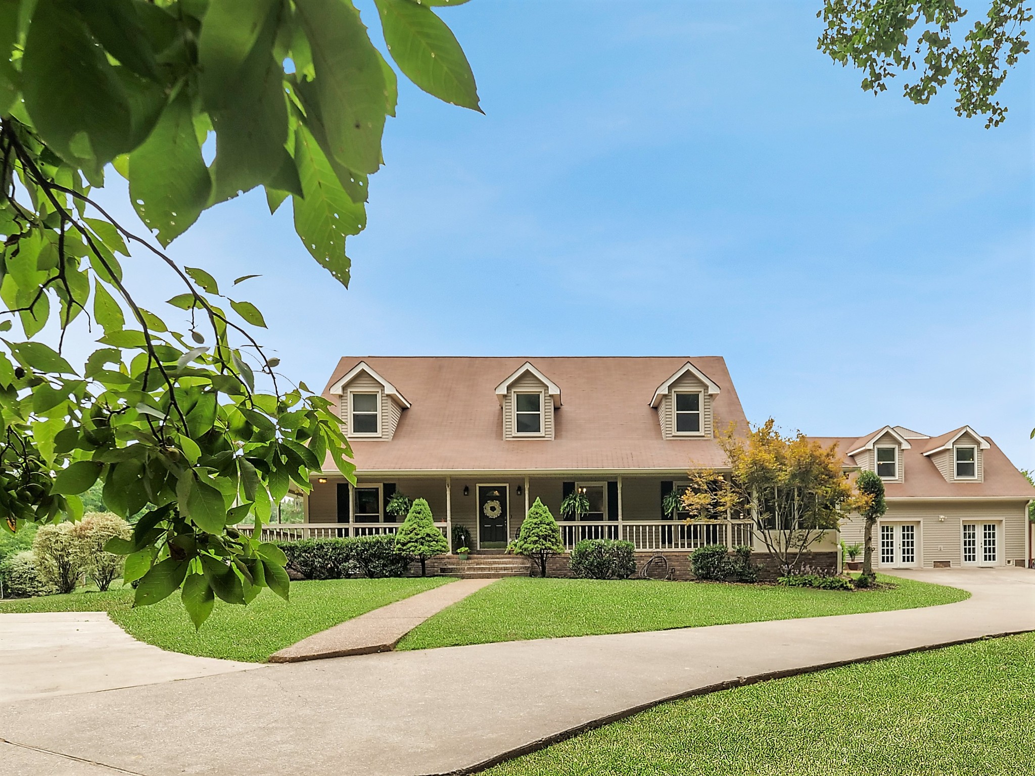 a front view of a house with a yard and potted plants