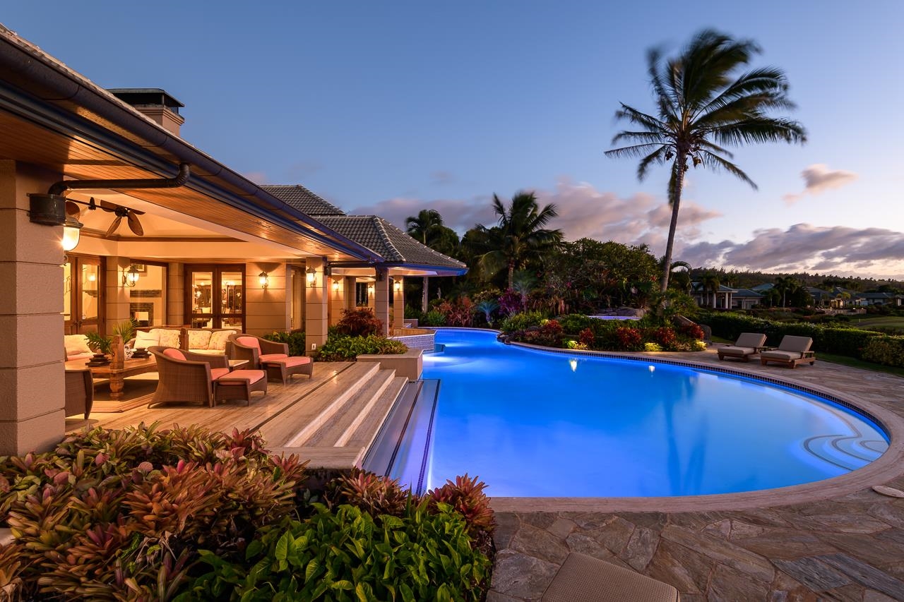 a view of a swimming pool with a table and chairs under an umbrella