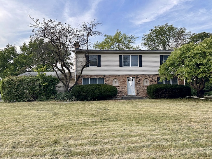 a view of a house with backyard and trees