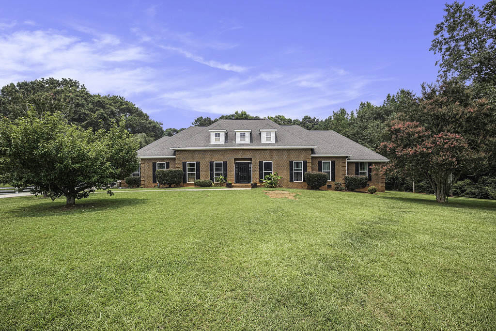 a front view of a house with a garden