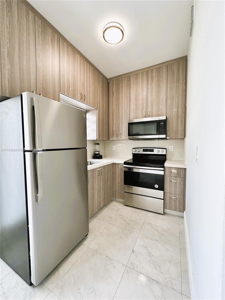 a kitchen with cabinets a refrigerator and a stove