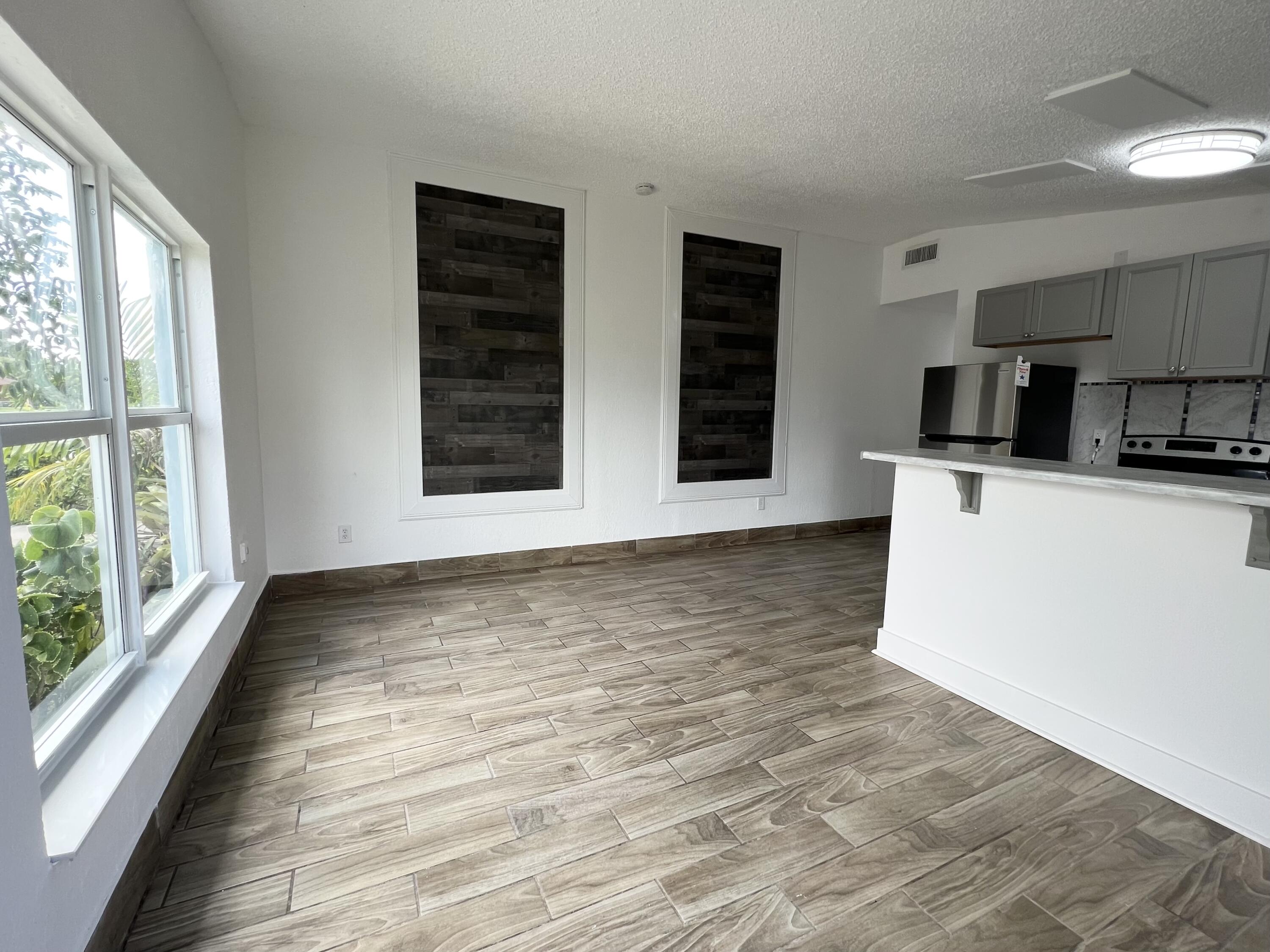 a view of a kitchen with wooden floor and electronic appliances