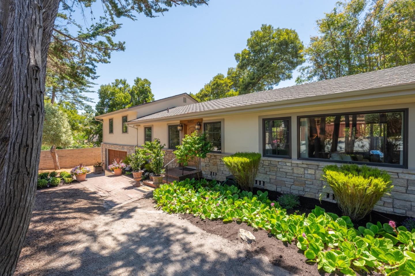 a front view of a house with a yard and potted plants