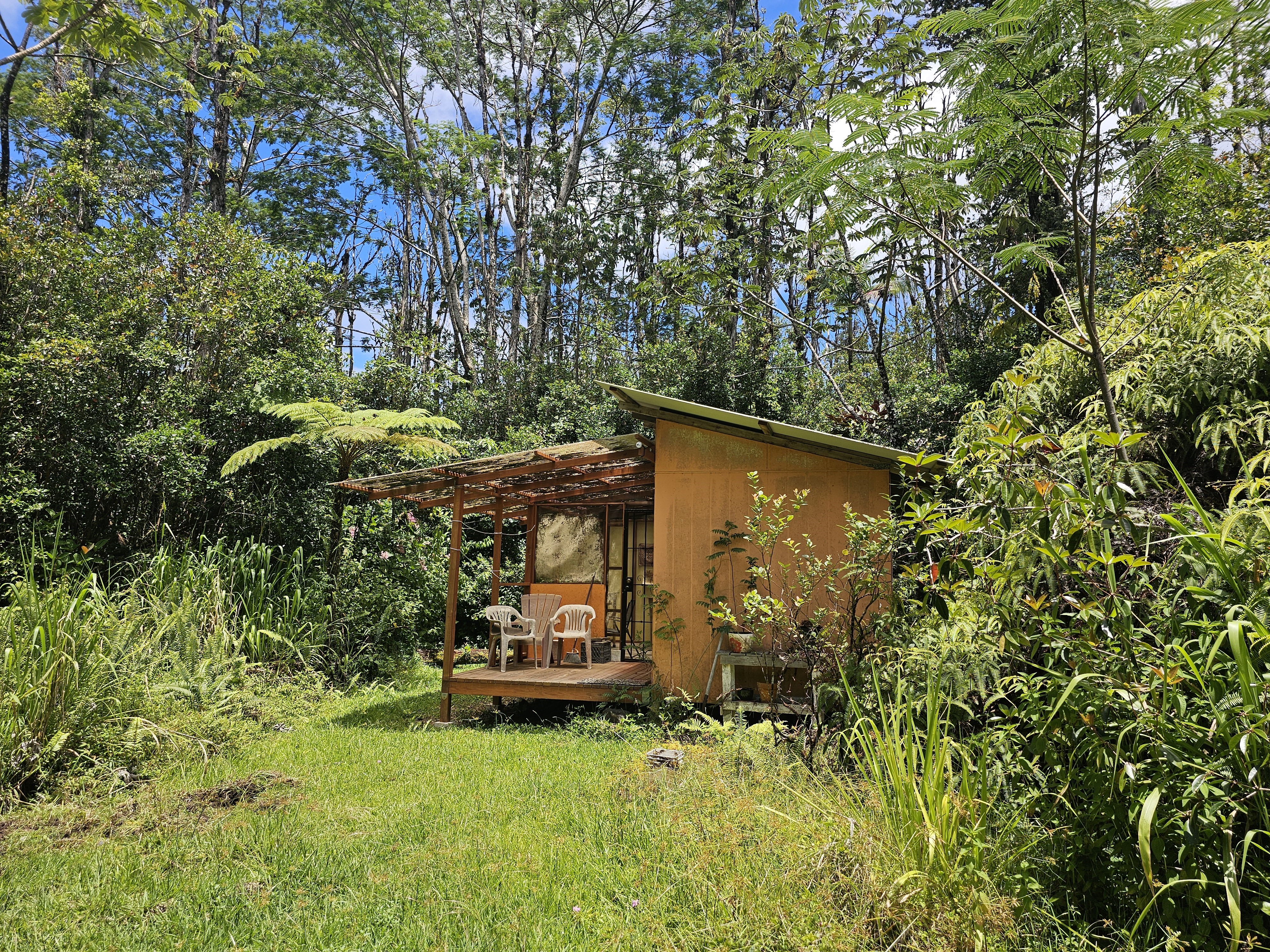 a backyard of a house with table and chairs under an umbrella