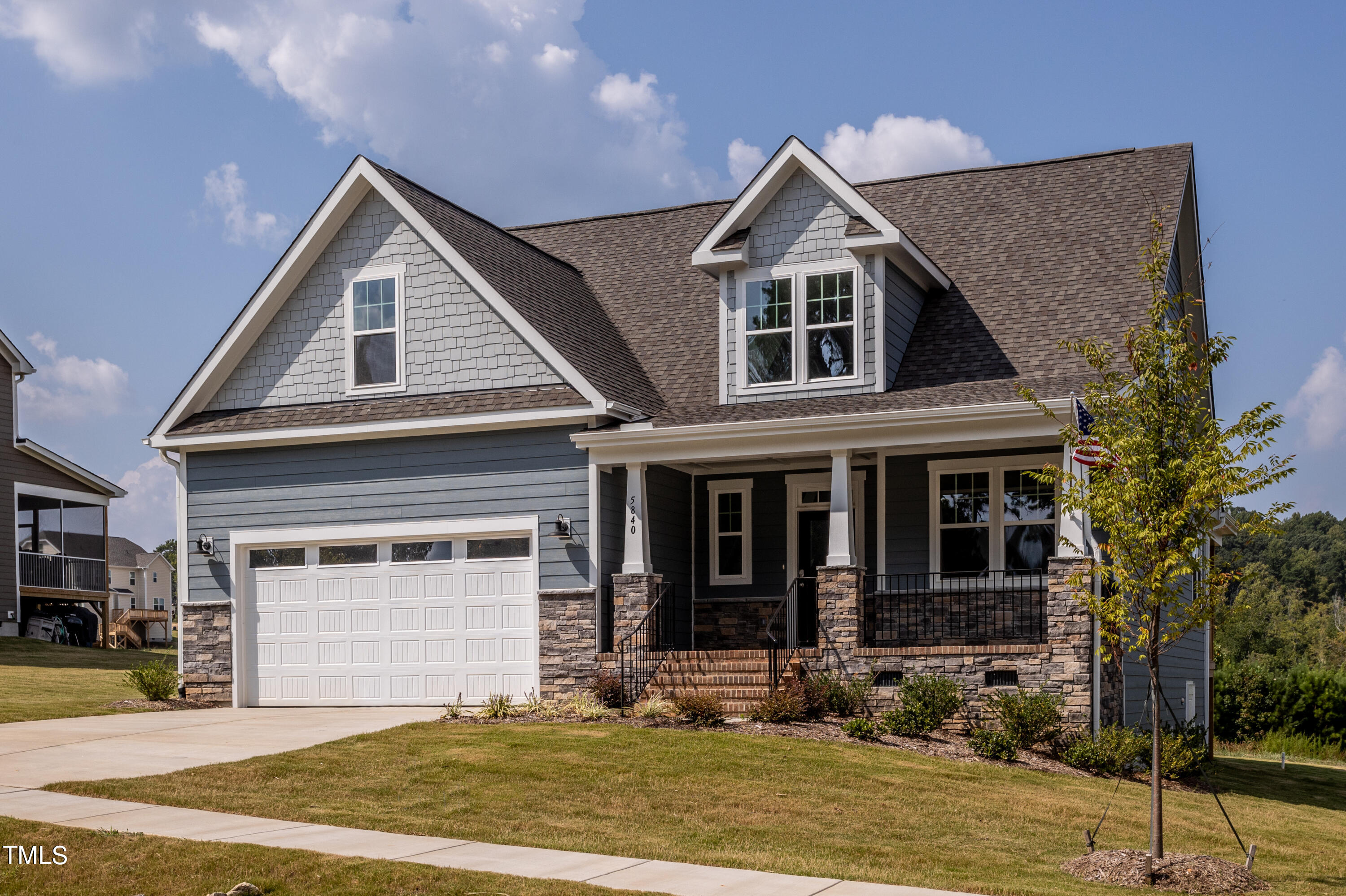 a front view of a house with yard and parking